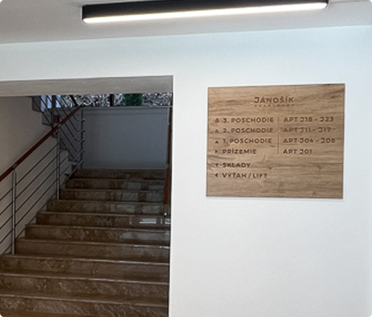 Drevené informačné značenie na stene Apartmánového domu Jánošík vyrobené podľa grafického návrhu